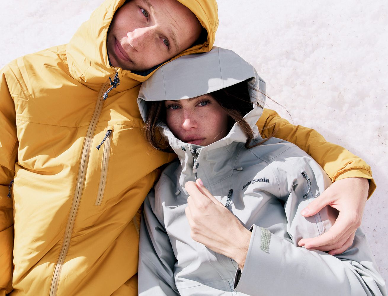 Couple in winter jackets cuddled up in the snow