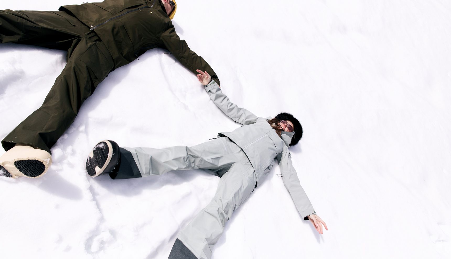 Two people making snow angels in fresh snow